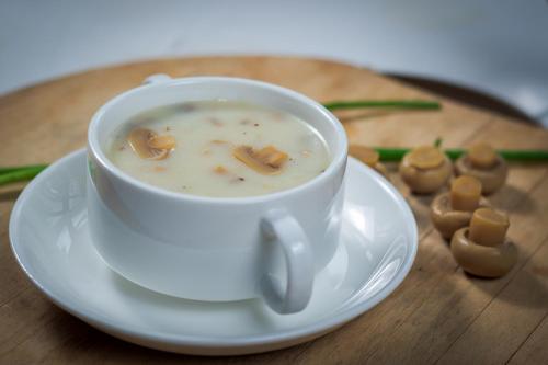 a cup of soup on a plate on a table at Ruby True Hotel in Bagan