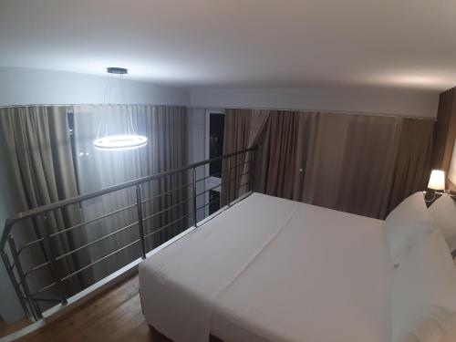 a bedroom with a white bed and a light at Bistrica Hotel in Sarandë