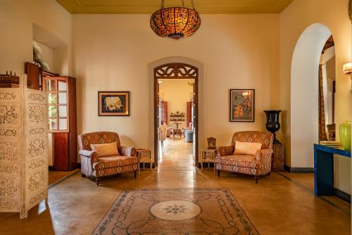 a living room with two chairs and an entry way at Amrapali-House of Grace in Bambolim