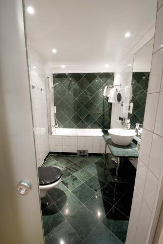 a bathroom with a sink and a toilet at Elite Stora Hotellet Örebro in Örebro