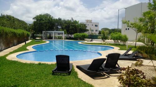 a swimming pool with two chairs and a swimming poolvisorvisor at CasaMEXH Lunamar - Ideal para familias, vacaciones o homeoffice cerca 5a Av, Xcaret, Playa in Playa del Carmen