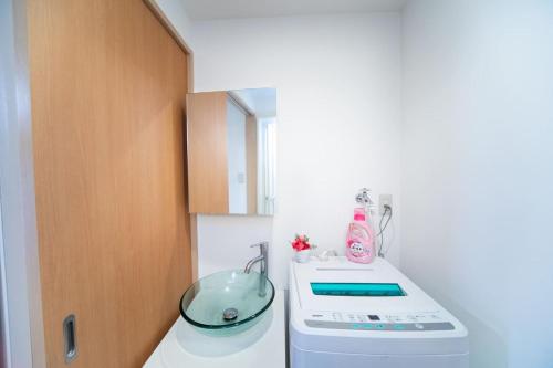 a kitchen with a bowl on top of a washing machine at Miraie Osaka Higashinari202 in Osaka
