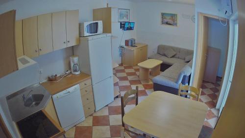 cocina pequeña y sala de estar con sofá y mesa en Apartments Pag-Travel, en Novalja