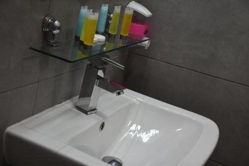 a bathroom sink with a glass shelf above it at Rimon Cyprus Israeli Kosher Rooms in Larnaka