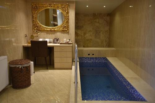 La salle de bains est pourvue d'une baignoire avec un lavabo et un miroir. dans l'établissement Rimon Cyprus Israeli Kosher Rooms, à Larnaka