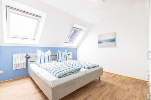 a bedroom with a bed with blue walls and windows at Siedlerstraße in Leer