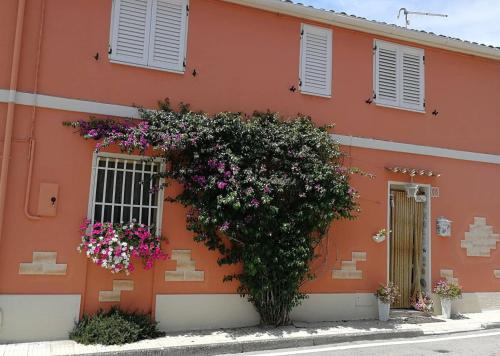 un edificio arancione con dei fiori sul lato di Da Mamma e Papà Sirolo a Sirolo