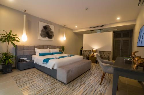a bedroom with a bed and a living room with a desk at Damrei Residence & Spa in Siem Reap