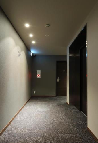 an empty room with a hallway with a door at HOTEL PROMOTE HIROSHIMA in Hiroshima