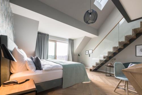 a bedroom with a bed and a staircase at Gut Kump Gastronomie und Hotel in Hamm