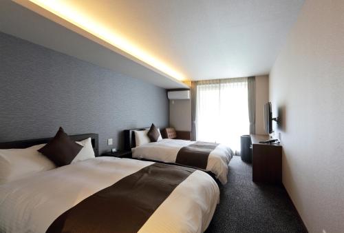 Ένα ή περισσότερα κρεβάτια σε δωμάτιο στο HOTEL PROMOTE HIROSHIMA