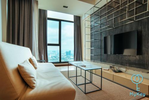 a hotel room with a tv and a couch and a table at Expressionz Professional Suites by MyKey in Kuala Lumpur