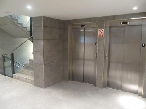 an elevator lobby with two elevators and stairs at Iraipe Santuario de Arantzazu Hotel in Oñate
