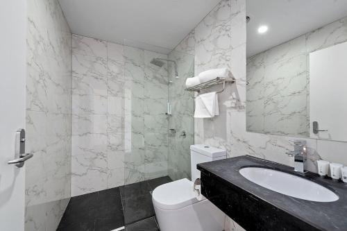 a white bathroom with a sink and a toilet at Areca Launceston in Launceston