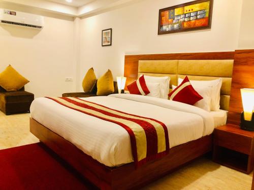 a bedroom with a large bed with red and yellow pillows at Red Crown Hotel in New Delhi