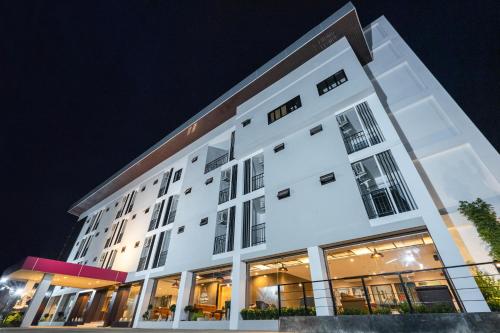 a white building with windows at night at U- Homehotel Nakhonpanom in Nakhon Phanom