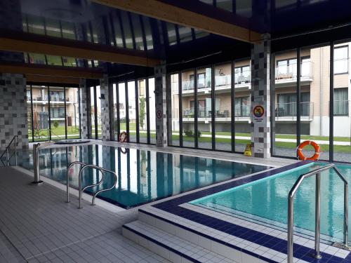 a large swimming pool in a building with windows at Apartamenty nad morzem & SPA BEST HOME 5 Mórz in Sianozety