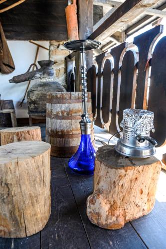 a blue vase sitting on a table next to some logs at Banskovilla Zlateva House in Bansko