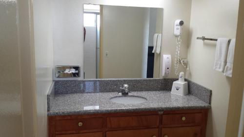 a bathroom with a sink and a mirror at Americas Best Value Inn Beaumont California in Beaumont