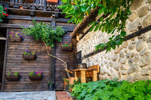 a stone wall with potted plants on it at Banskovilla Zlateva House in Bansko