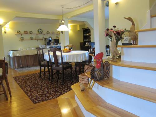 a dining room with a table and a kitchen at Auld Farm Inn B&B in Baddeck