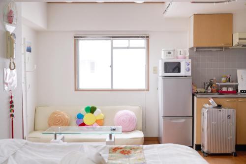 Habitación con sofá y cocina en sakura house, en Tokio