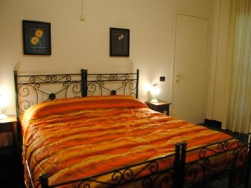 a bedroom with a bed with an orange blanket at Villa Axa in Casal Palocco