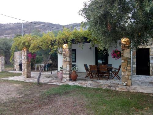 Cette maison dispose d'une terrasse avec une table et des chaises. dans l'établissement Villa Glaykos, à Thymonia Beach