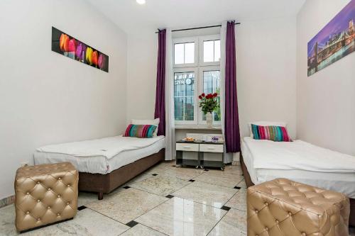 a room with two beds and a window at 3 City Hostel in Gdańsk