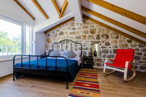 a bedroom with a bed and a red chair at Apartments Korita in Maranovići