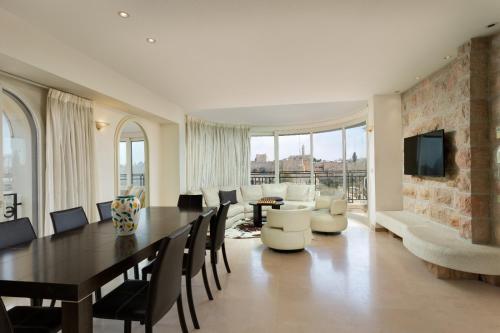 a dining room with a table and chairs and a living room at David Village Residences - Rental Israel in Jerusalem