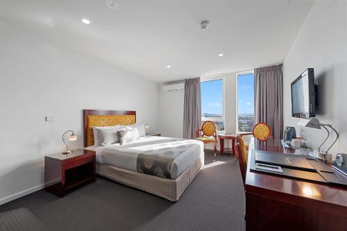 a hotel room with a bed and a flat screen tv at Areca Launceston in Launceston