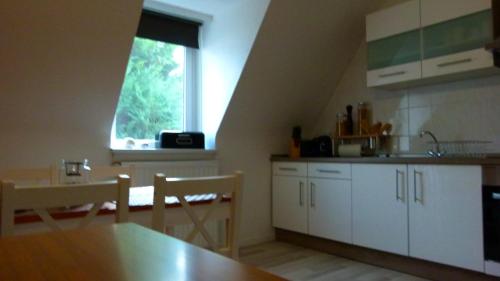 a kitchen with white cabinets and a table and a window at Casa Maria App. Jose 1. Obergeschoss in Sankt Wendel