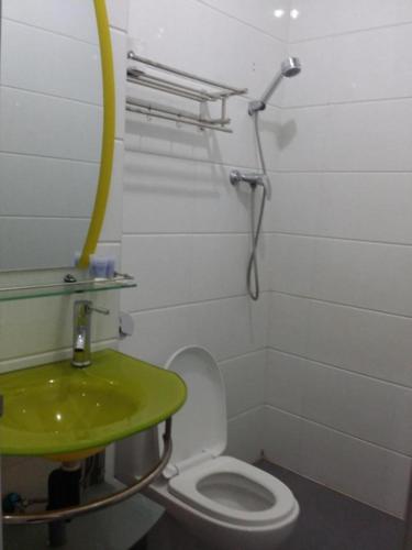 a bathroom with a green sink and a toilet at Maxi Inn in Bintulu