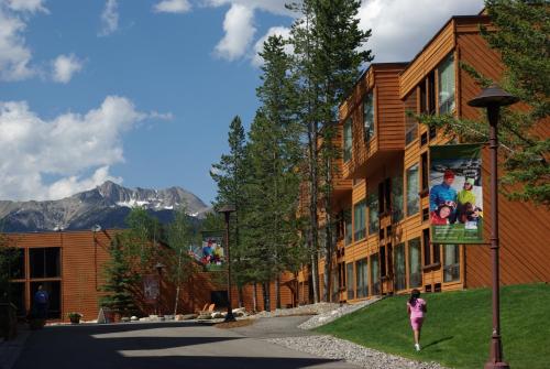 a girl walking down a street in front of a building at Huntley Lodge at Big Sky Resort in Big Sky