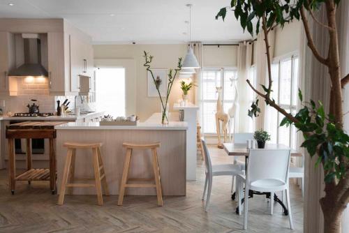 a kitchen with wooden stools and a table in a kitchen at Thornton Gap Guesthouse in Johannesburg