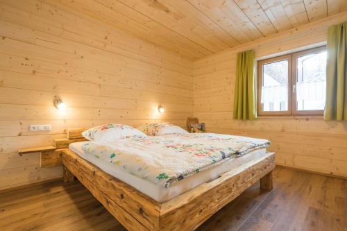 een slaapkamer met een bed in een houten kamer bij Landhaus Panorama in Bad Hindelang