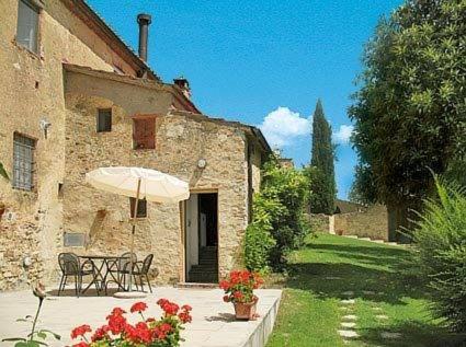 a patio with an umbrella and a table and chairs at Agriturismo La Moraia in Poggibonsi
