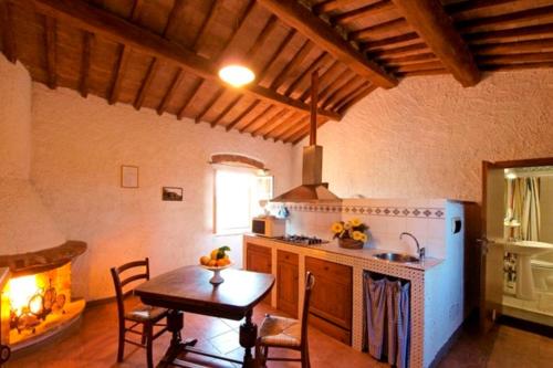 a kitchen with a table and a stove top oven at Agriturismo La Moraia in Poggibonsi