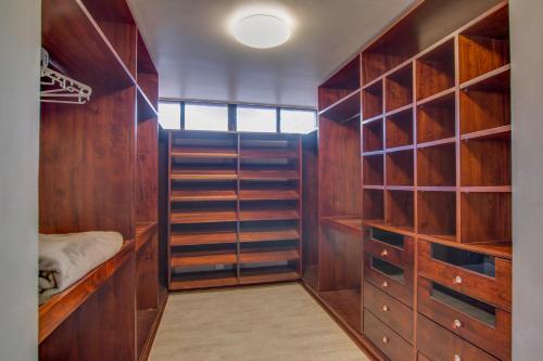 a walk in closet with wooden cabinets and shelves at Migdash Guesthouse in Hartbeespoort