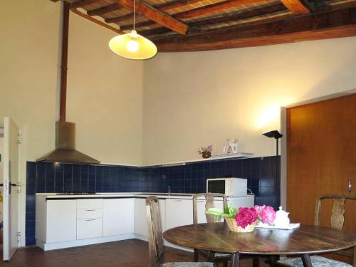 a kitchen with a table with flowers on it at Agriturismo La Moraia in Poggibonsi