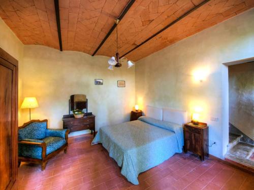 a bedroom with a bed and a chair in a room at Agriturismo La Moraia in Poggibonsi