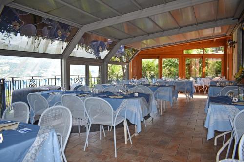 a banquet hall with blue tables and white chairs at Albergo Ristorante Conca Azzurra in Colico