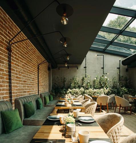 a dining room with tables and chairs and a brick wall at Reverence Boutique Hotel in Varna City