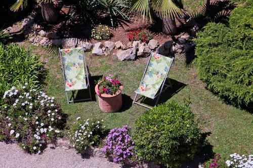 a garden with two chairs and a pot of flowers at Hôtel La Villa Cap d’Antibes in Juan-les-Pins