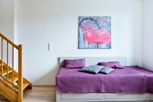ドルニー・モラヴァにあるApartmány Dolní Moravaの階段付きの部屋のベッド1台(紫のシーツ付)