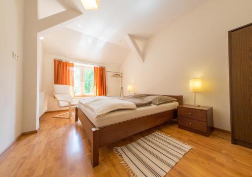 a bedroom with a bed and a chair and a window at Apartament Zdrojowy in Lądek-Zdrój