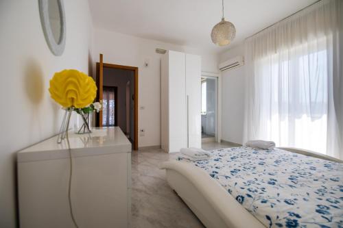 a bedroom with a bed and a vase with a yellow flower at Villa Salvius in Scafati