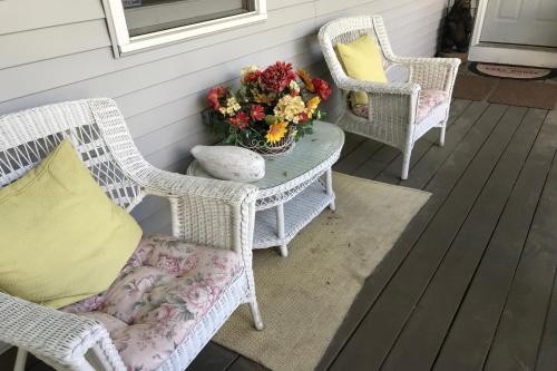 two chairs and a table with a vase of flowers on a porch at 4 Bed 2 Bath Vacation home in Ossipee in Ossipee