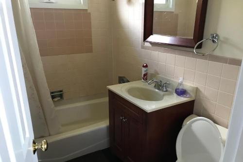 a bathroom with a sink and a toilet and a tub at 4 Bed 2 Bath Vacation home in Ossipee in Ossipee